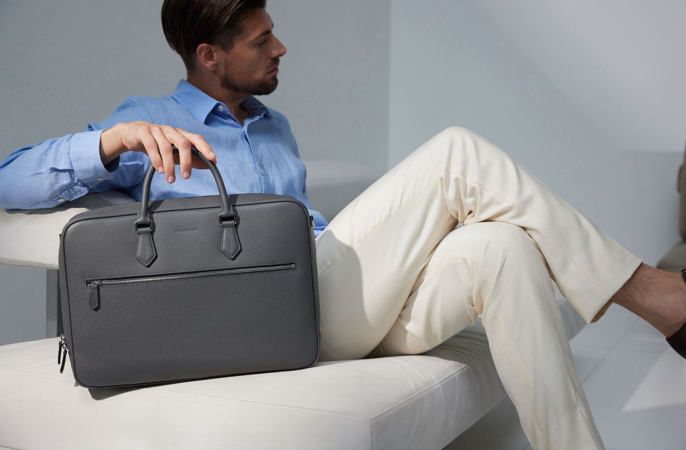 Modern businessman in the office, equipped with a stylish leather briefcase.