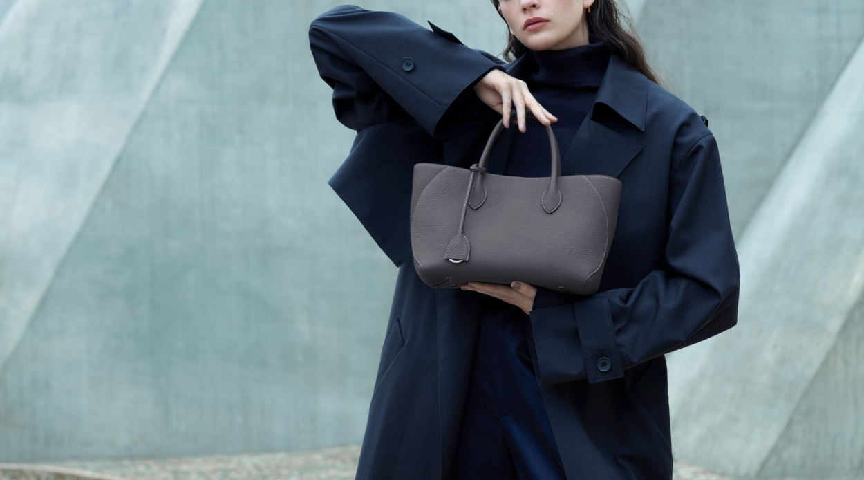 Woman presents a perfectly groomed leather bag in winter