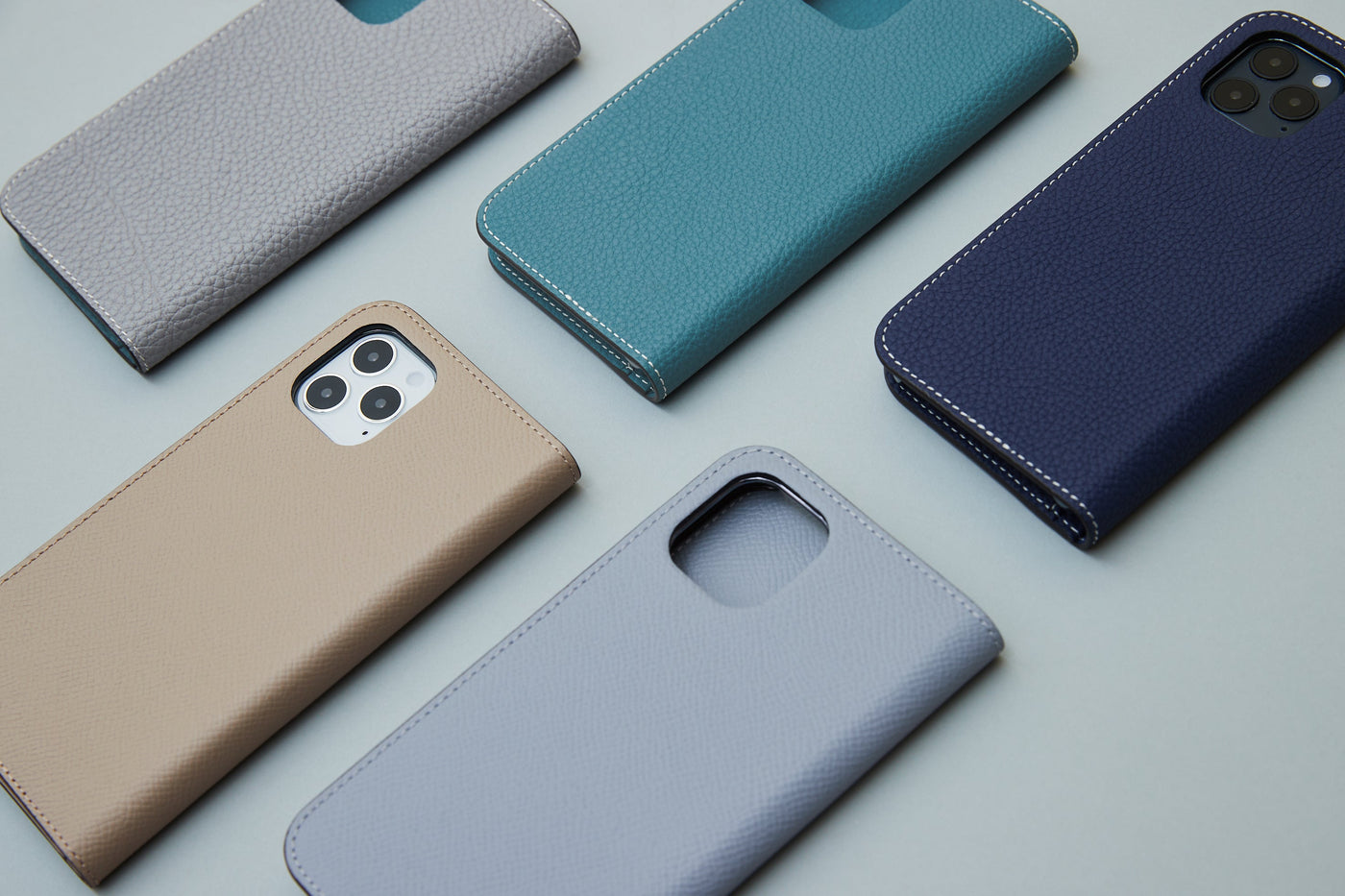 iPhone 16 and iPhone 16 Pro in a protective leather case in different colors